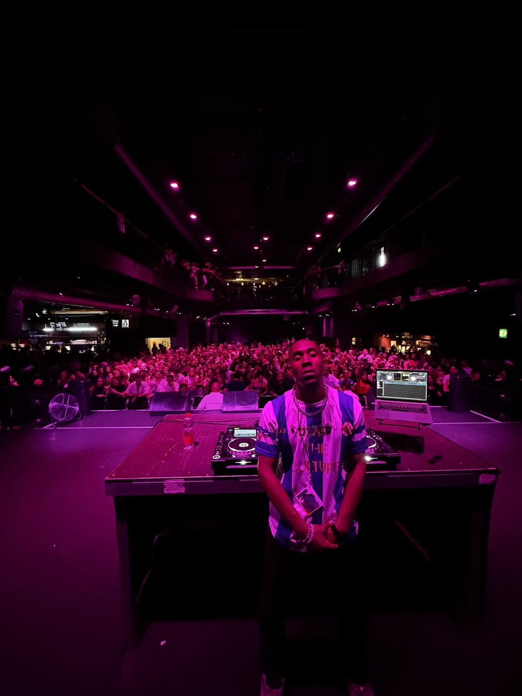 Booth facing a pink-lit arena